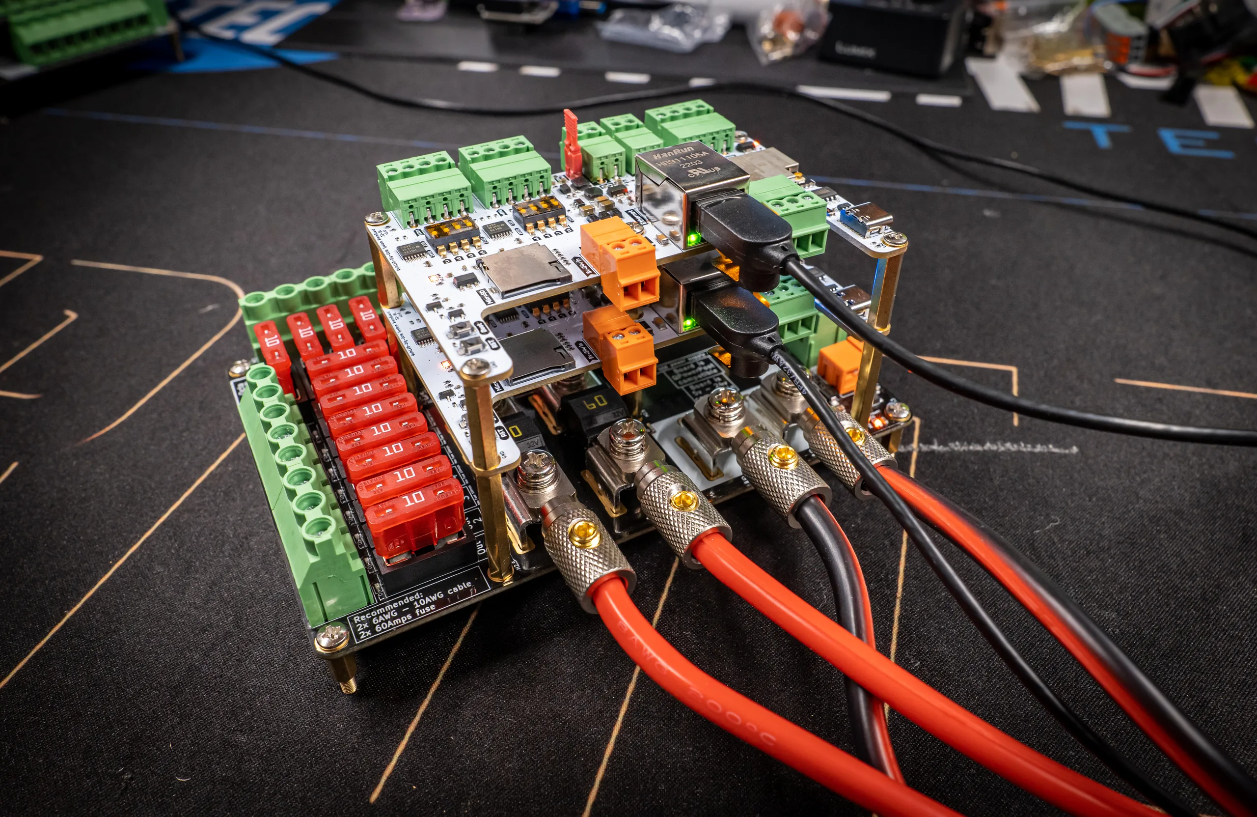 QuinLED Dig-Octa Power-7HC wired for full load: thick red power cables on M5 bolt terminals feeding a stack topped by white brainboards