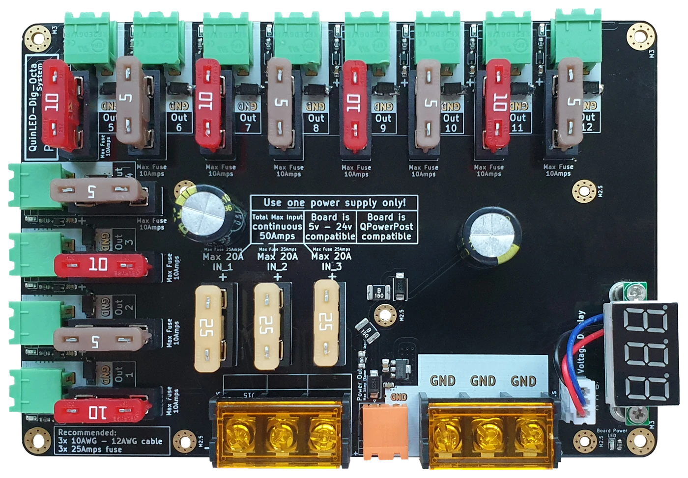 QuinLED Dig-Octa Power-5 from above: 12 green pluggable outputs with blade-fuse sockets, three barrier-block inputs, brass busbar posts, red voltage display